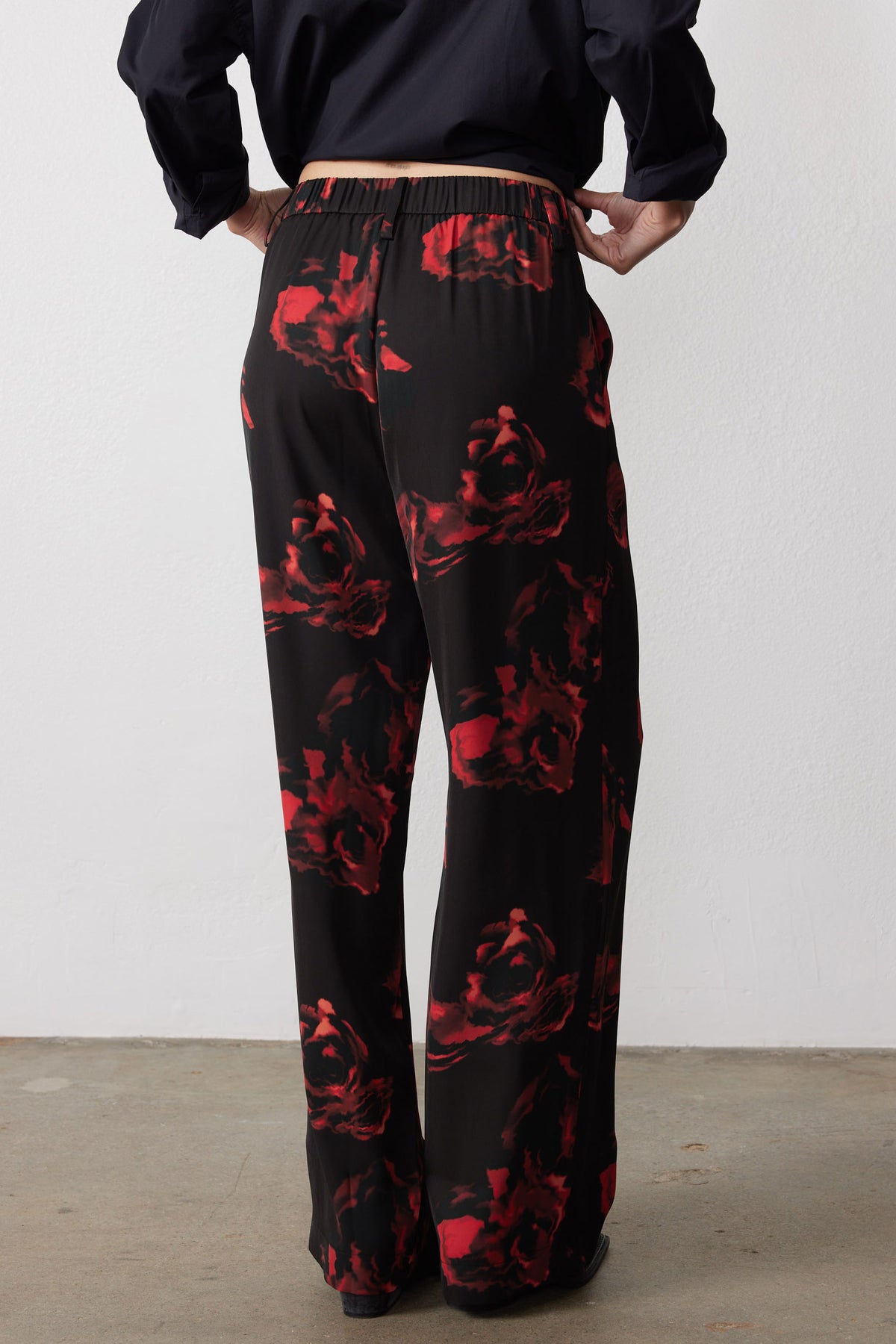 Wide-leg pants with elastic waistband and black with red floral print, back view