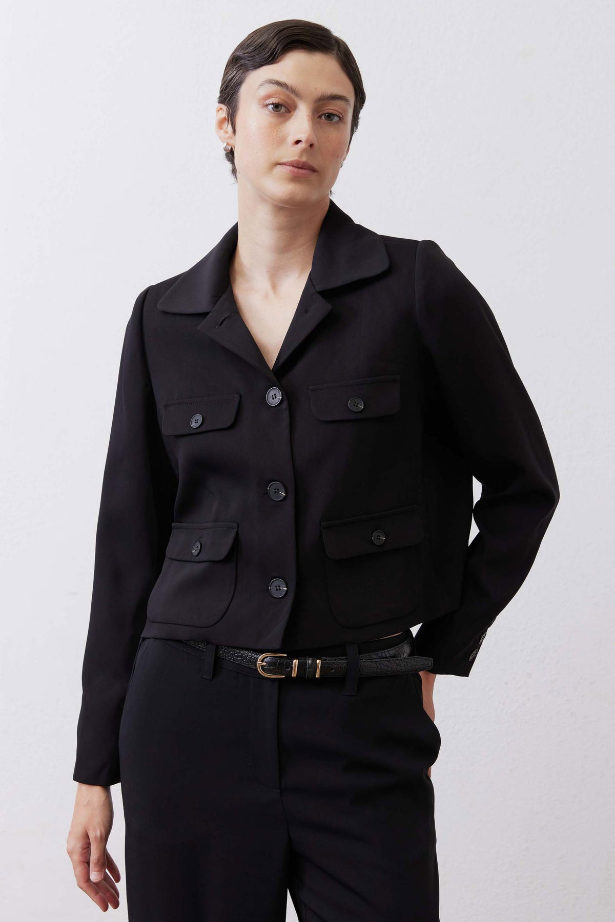 Black collared classic jacket with button front, flap chest pockets, and utility flap pockets