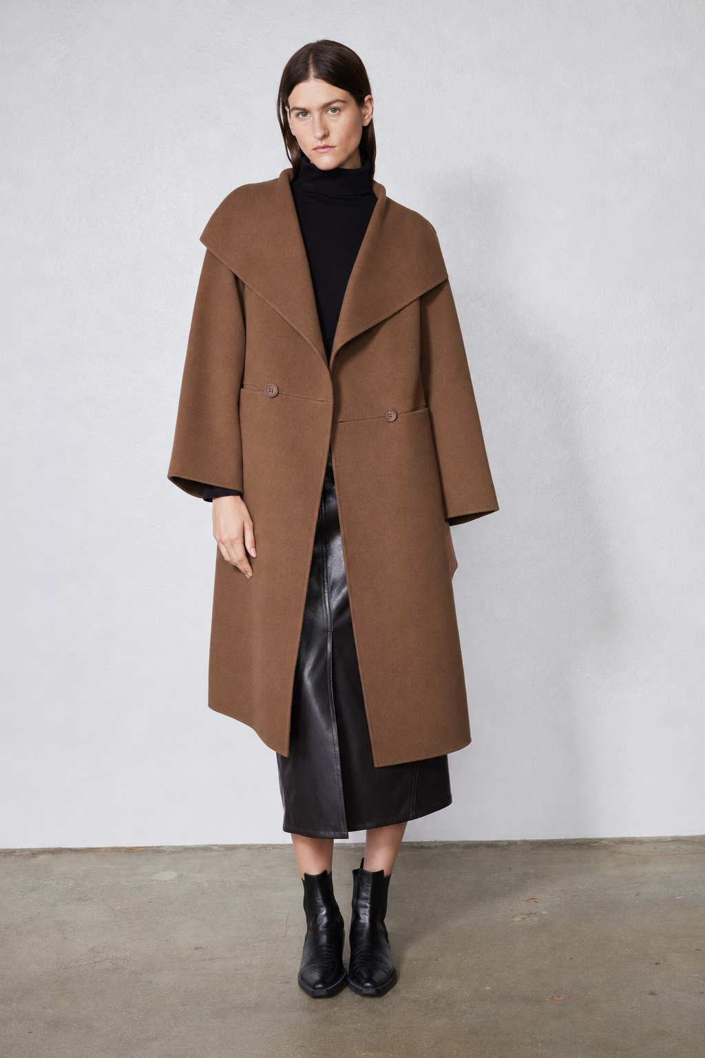 Dark taupe oversized wool coat with pointed collar, front buttons, and patch pockets.