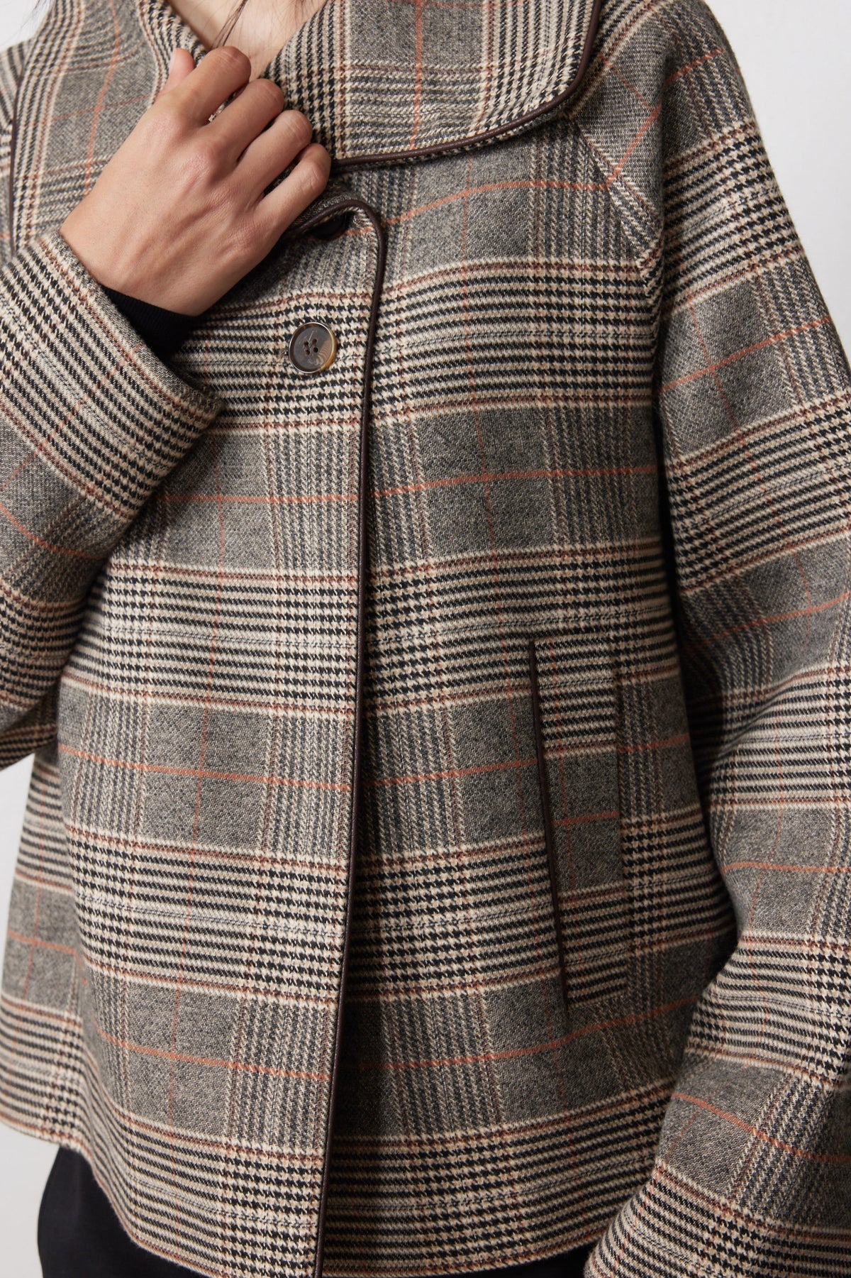 Brown plaid jacket detail: notched collar and button front placket
