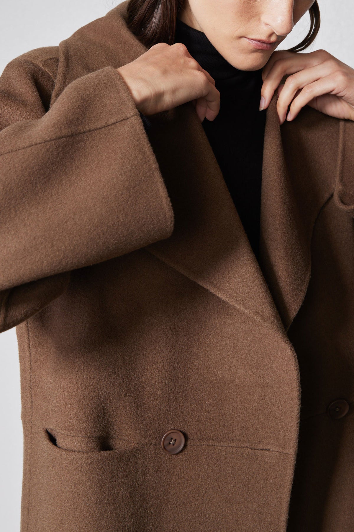 Dark taupe wool coat close-up of collar edge and two-button front placket