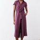 Maroon cropped jumpsuit with short sleeves, V-neck, and tied waist, front view