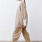 Side view of oatmeal knit kimono cardigan with wide sleeves and buttoned cuffs