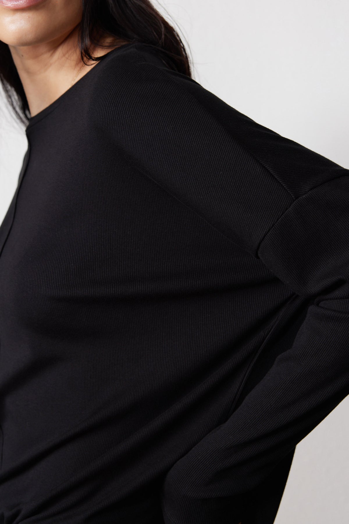 Close-up of the black ribbed pajama top's fabric and sleeve seam