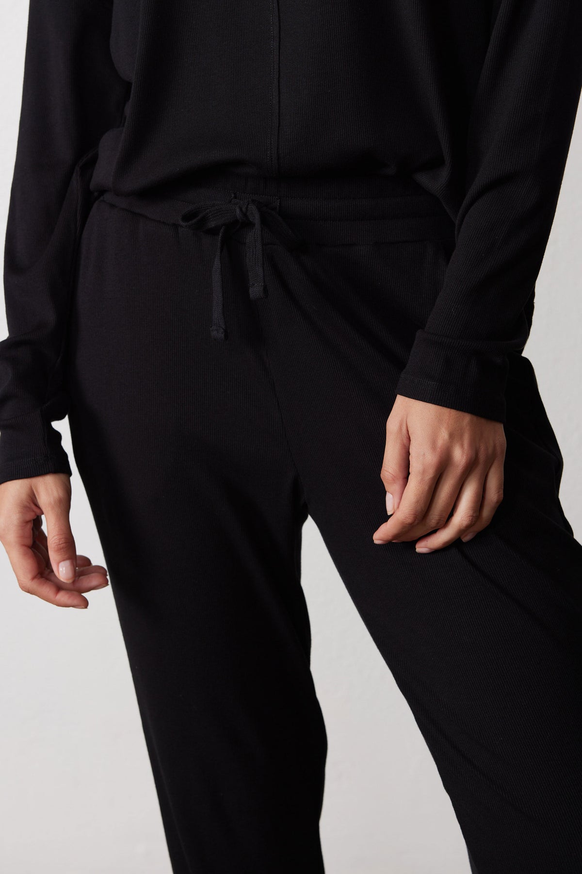 Close-up of the black pajama pants' drawstring waist and pocket