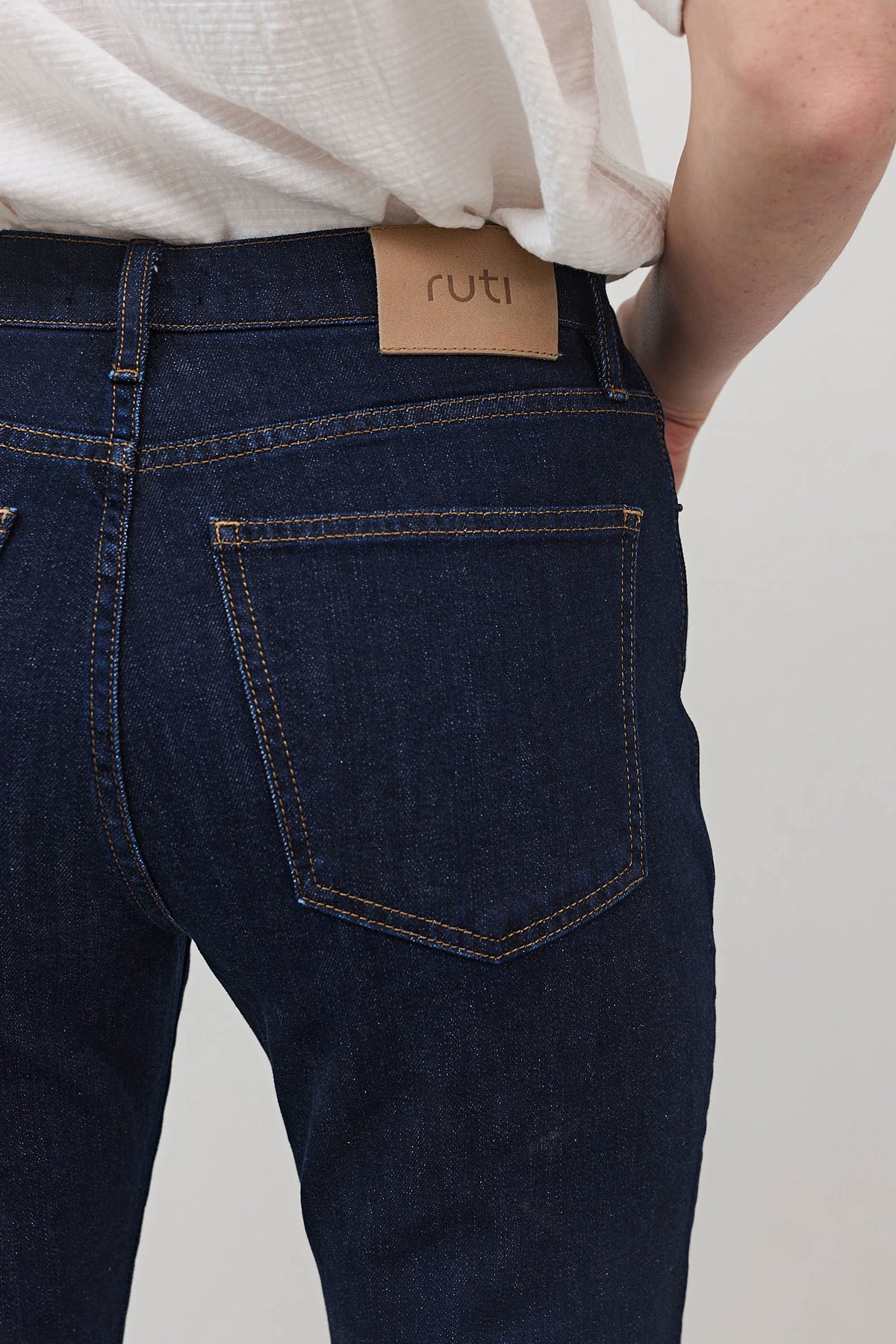 Dark wash mid-rise straight jeans, back yoke and leather patch, belt loops