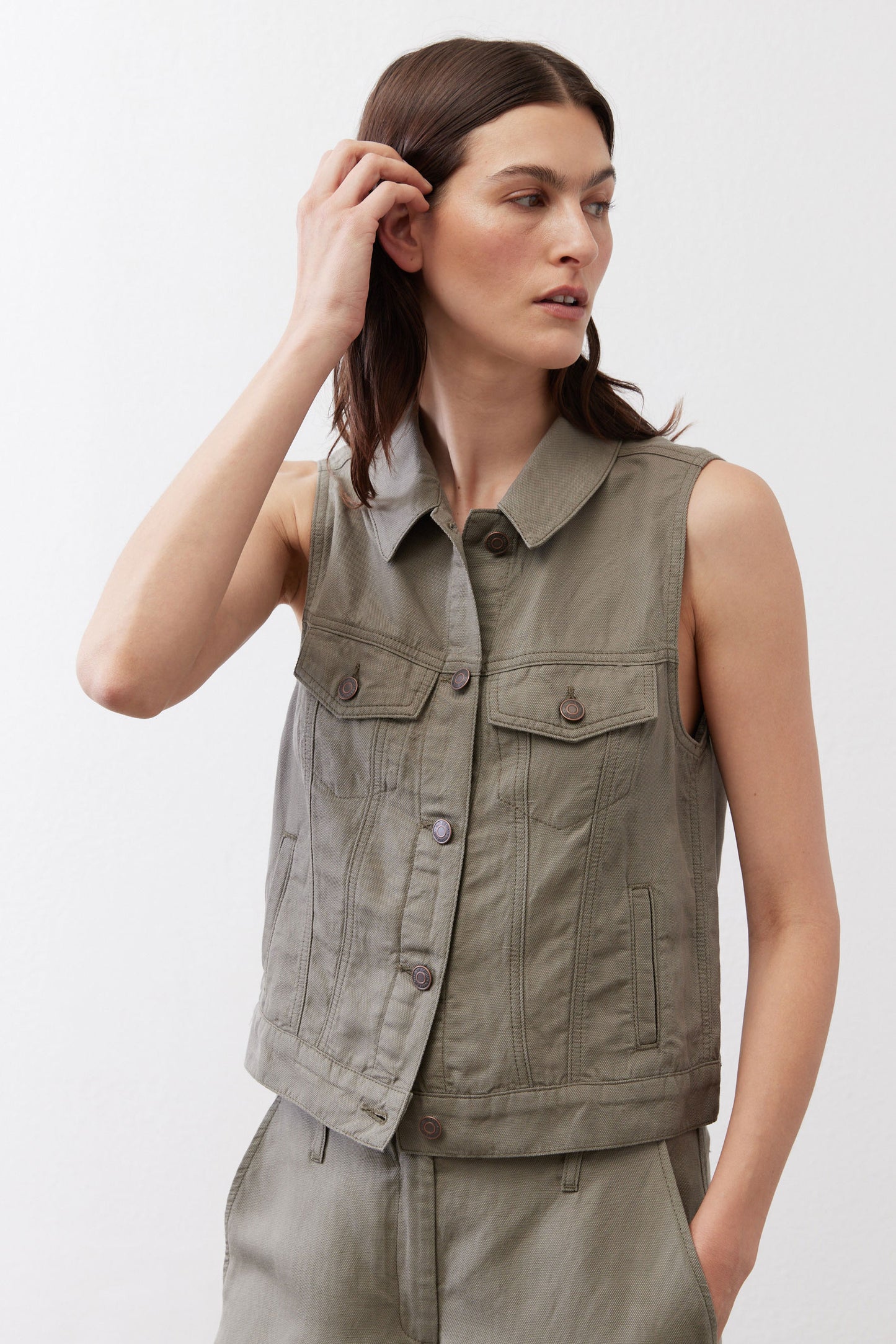 Olive green cropped task vest three-quarter view with button collar and flap pockets