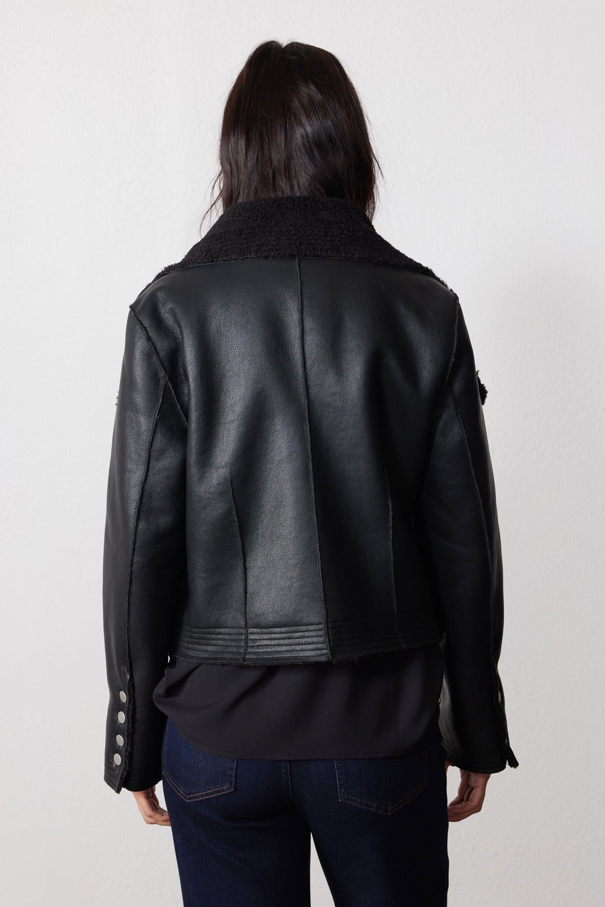Black reversible shearling moto jacket, back view with leather-look exterior and plush collar