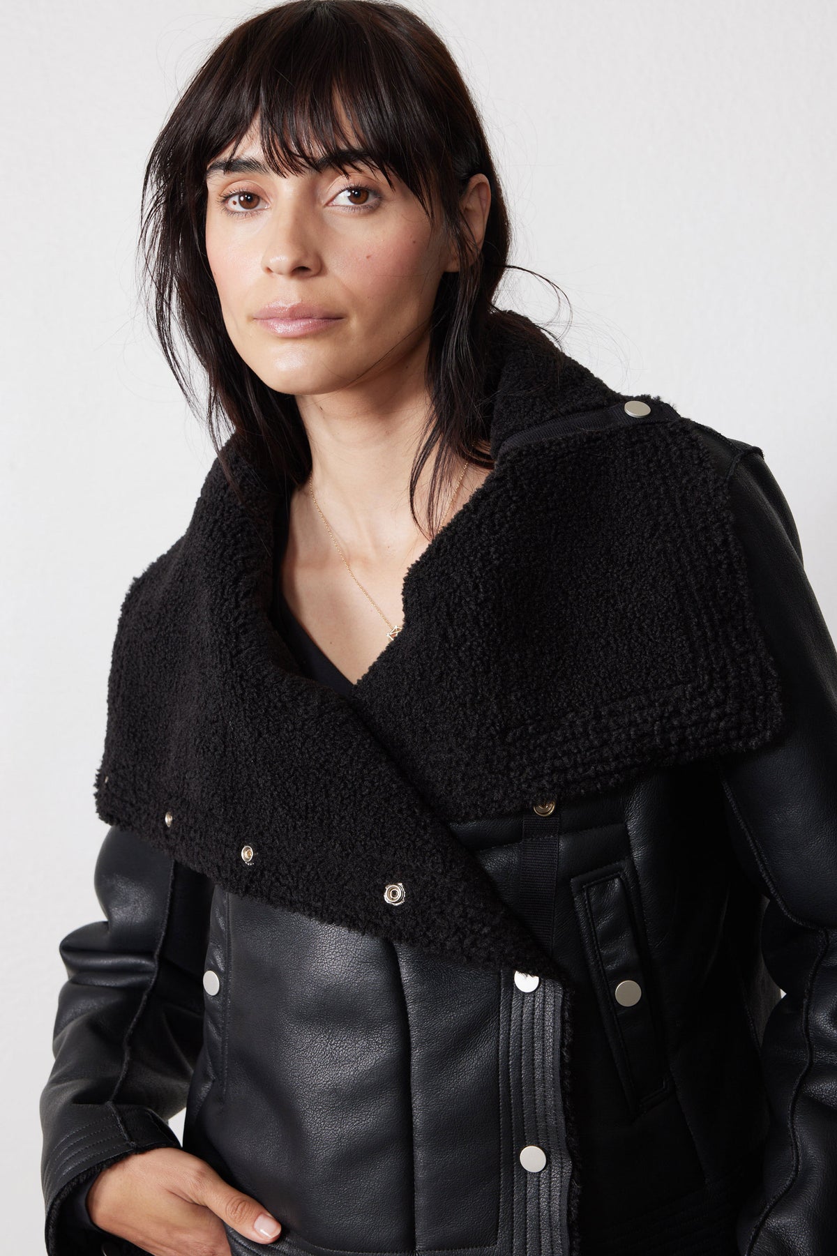 Black reversible shearling moto jacket with wide plush lapels and silver-tone snaps