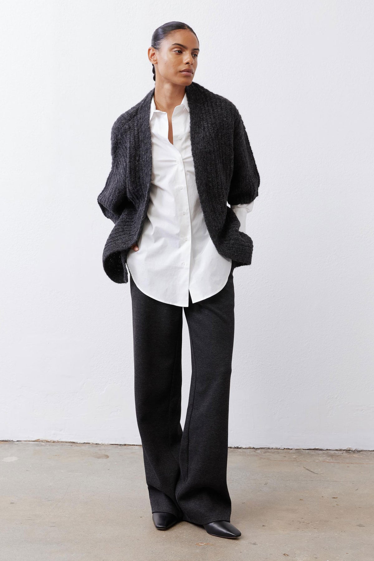 White button-down tunic layered under a dark cardigan with long sleeves