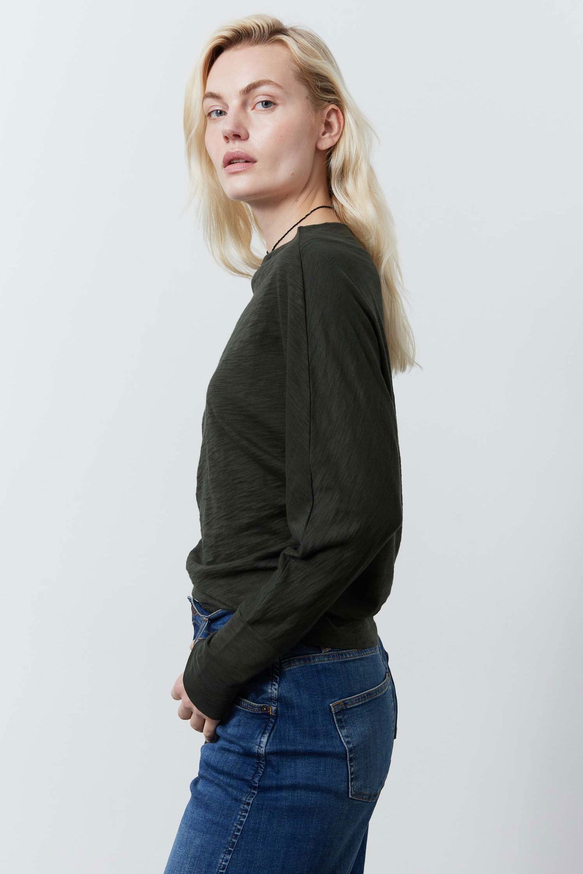 Forest green dolman top side view with long fitted-at-cuff sleeves