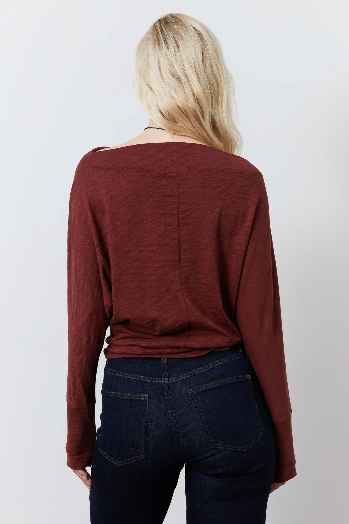Reddish-brown dolman long-sleeve top from back with curved seam