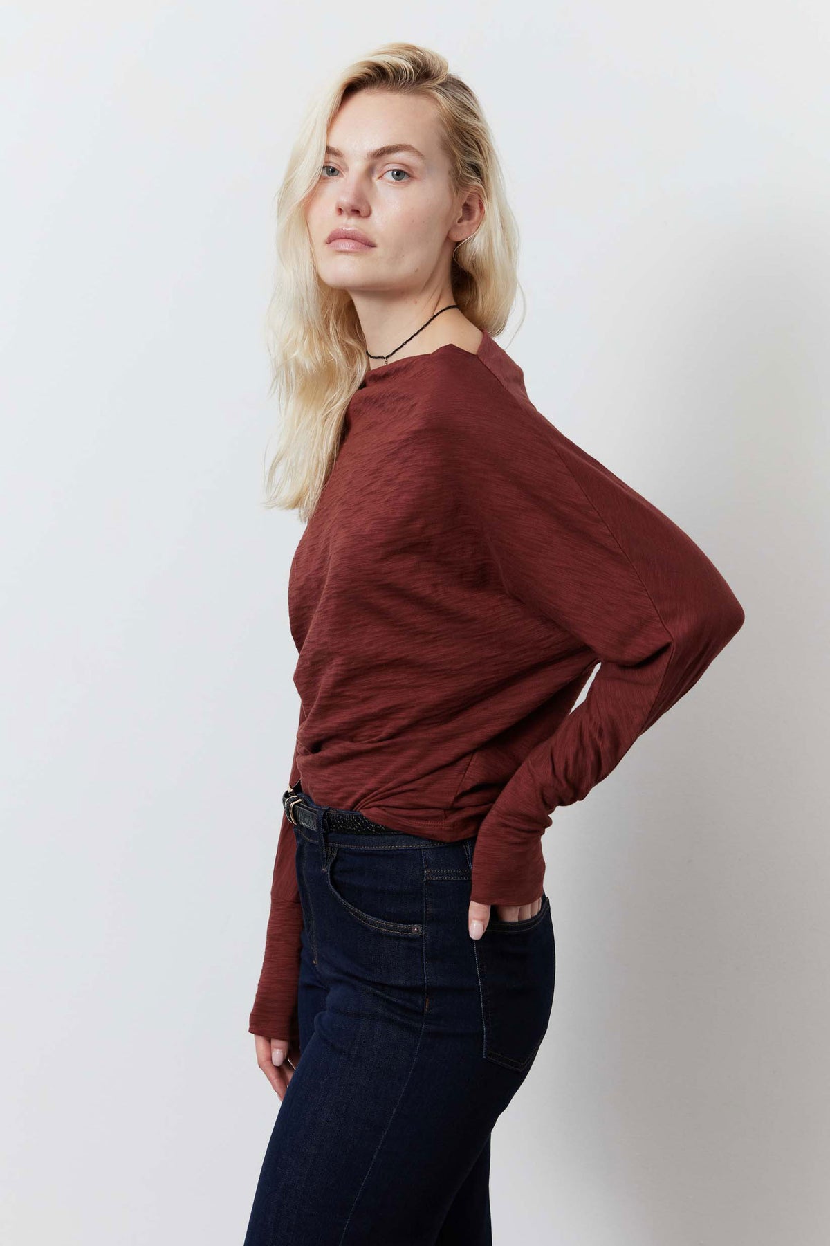 Reddish-brown dolman top with long sleeves and draped shoulder line
