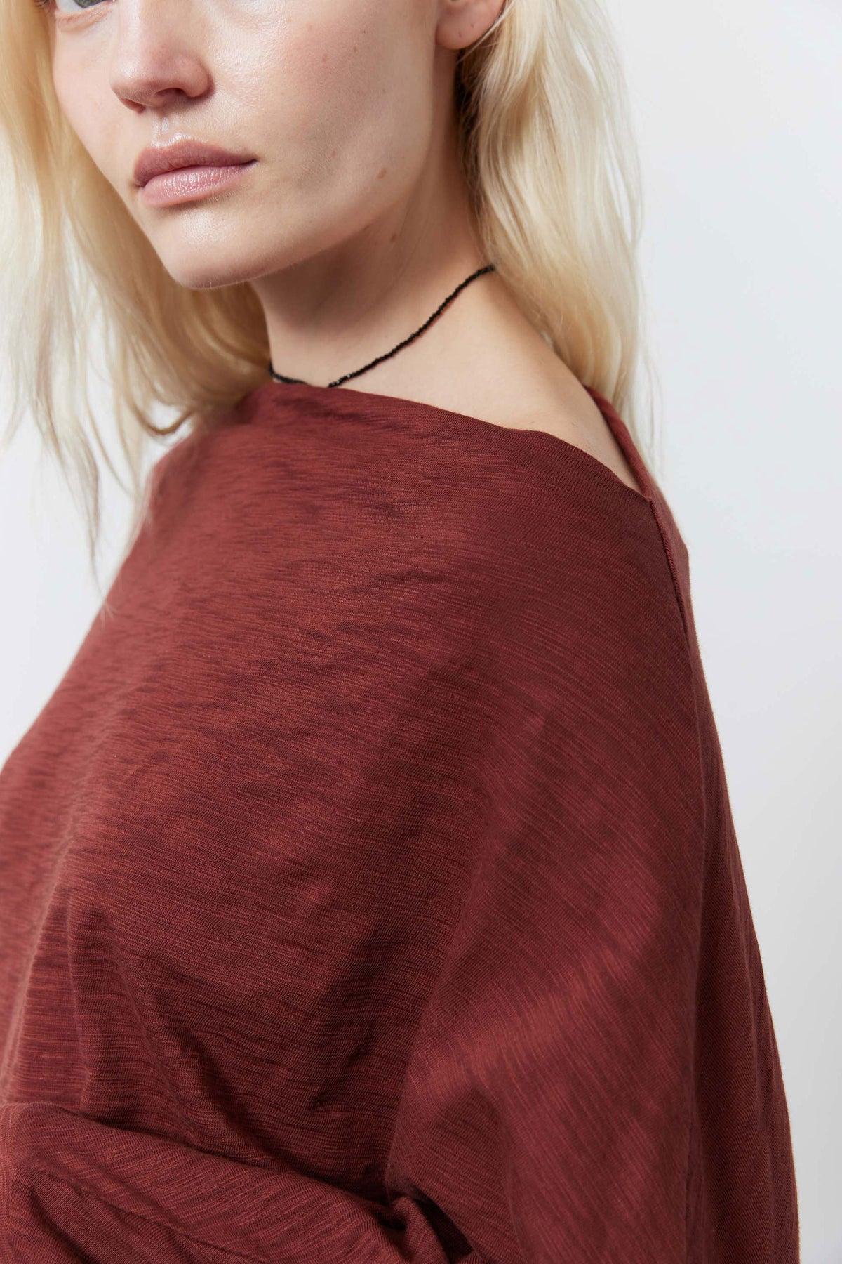 Reddish-brown dolman top with draped knit texture and wide neckline