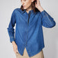 Medium-wash denim zip-front blouse with stand collar and buttoned cuffs, close-up