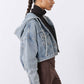 Washed-blue denim jacket, side view with buttoned chest and hood opening
