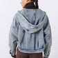 Washed-blue hooded denim jacket with drawstring, back view over brown pants