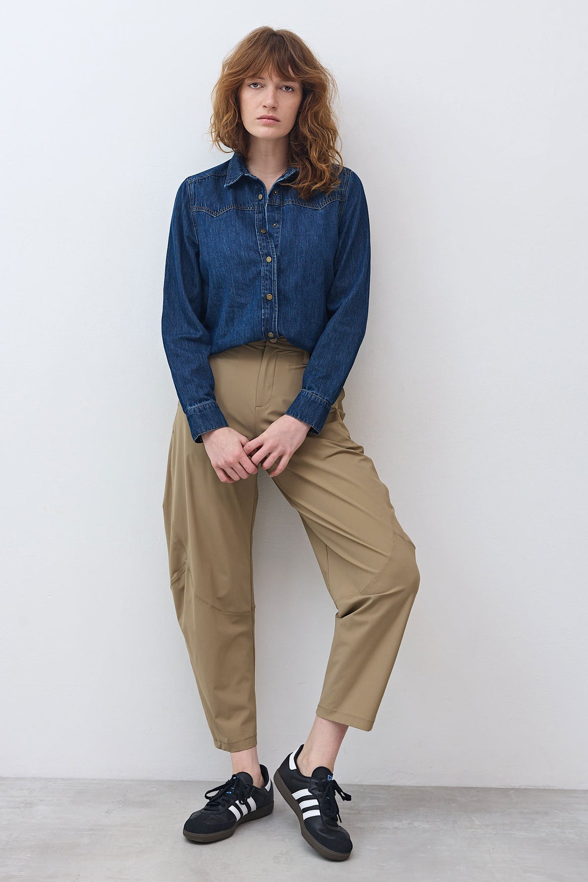 Medium-wash denim button-up shirt worn with tan trousers and black sneakers