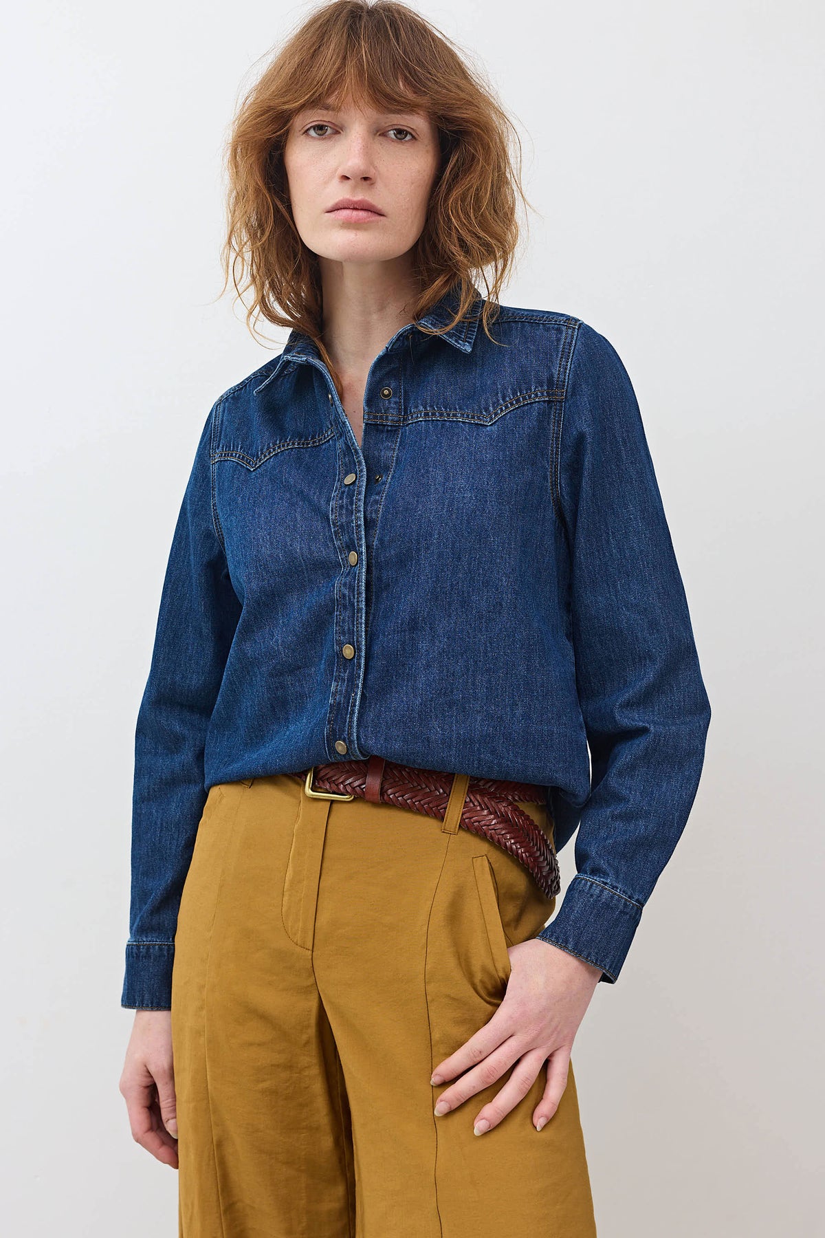 Medium-wash denim button-up shirt with pointed collar and buttoned front