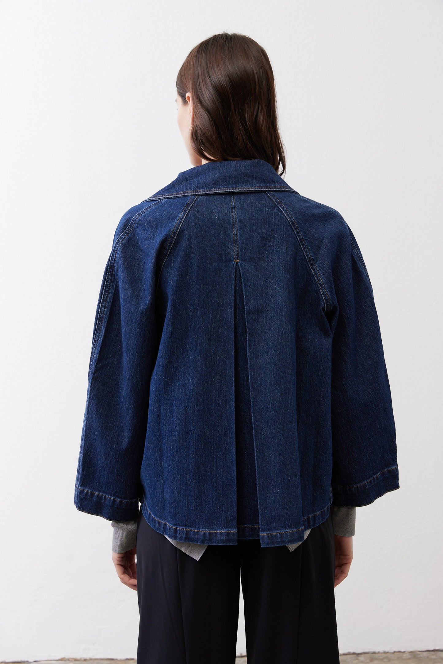 Denim cropped swing jacket back view, medium wash, center seam and curved hem