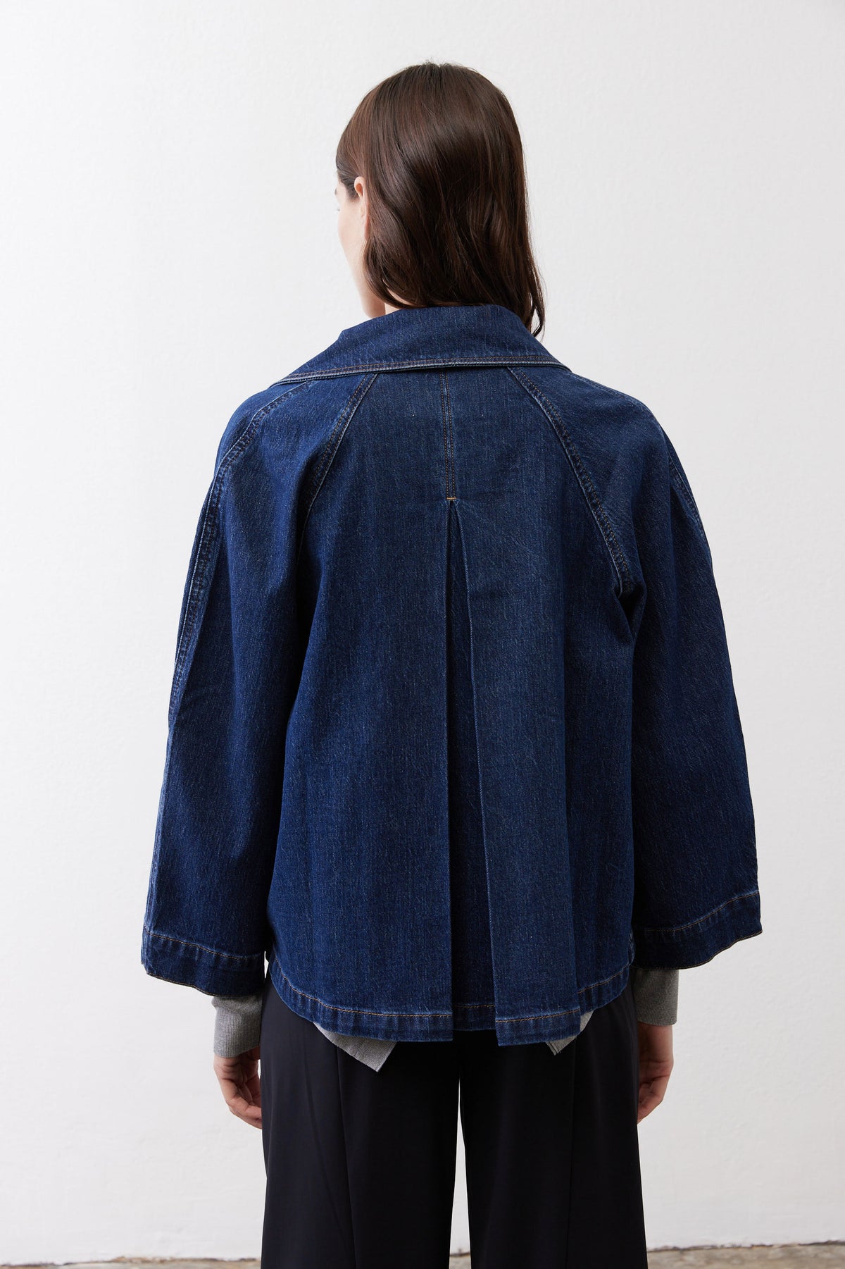 Denim cropped swing jacket back view, medium wash, center seam and curved hem