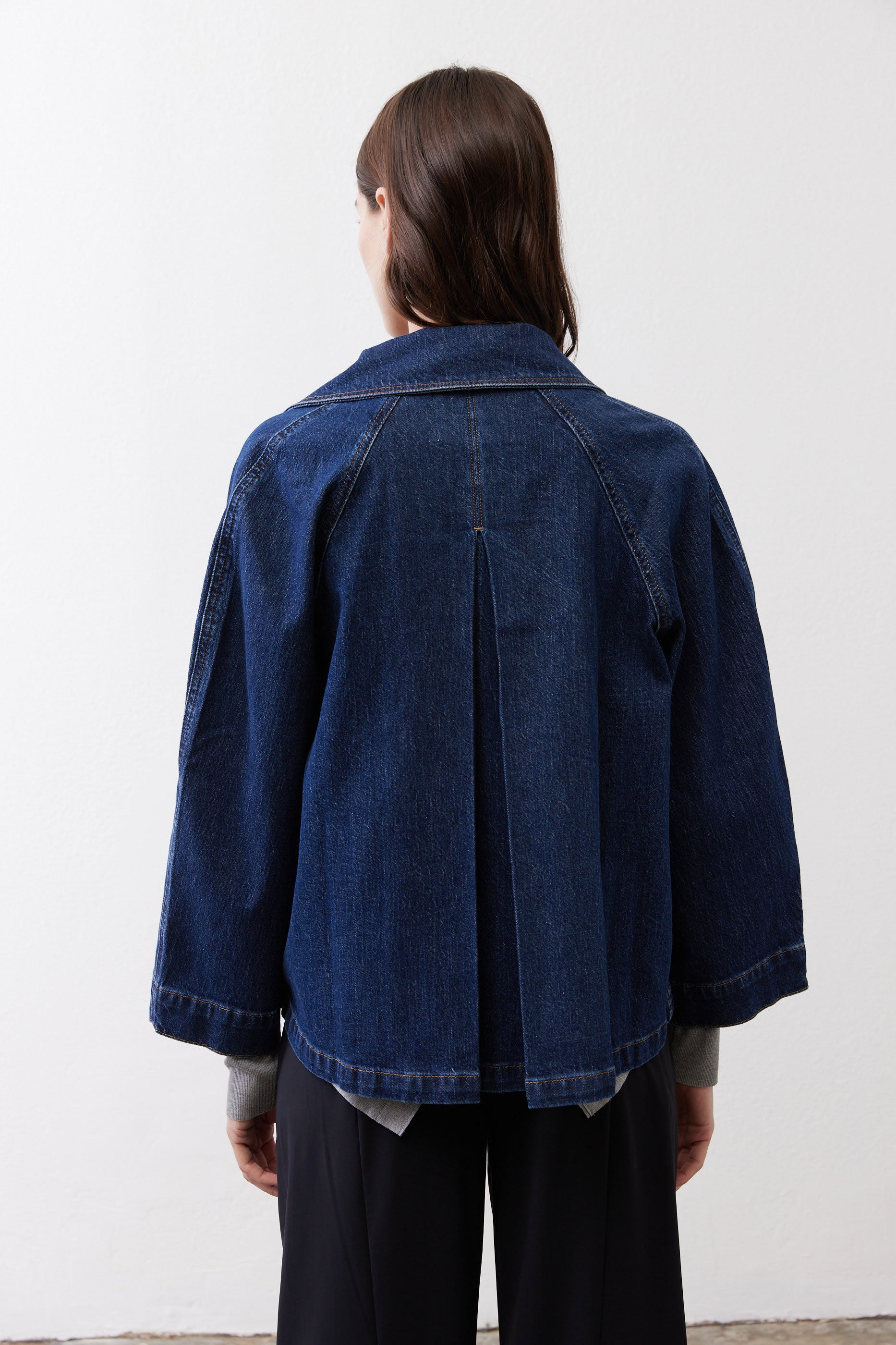 Denim cropped swing jacket back view, medium wash, center seam and curved hem