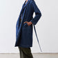 Navy denim trench coat with storm flap, long sleeves, and belted waist detail