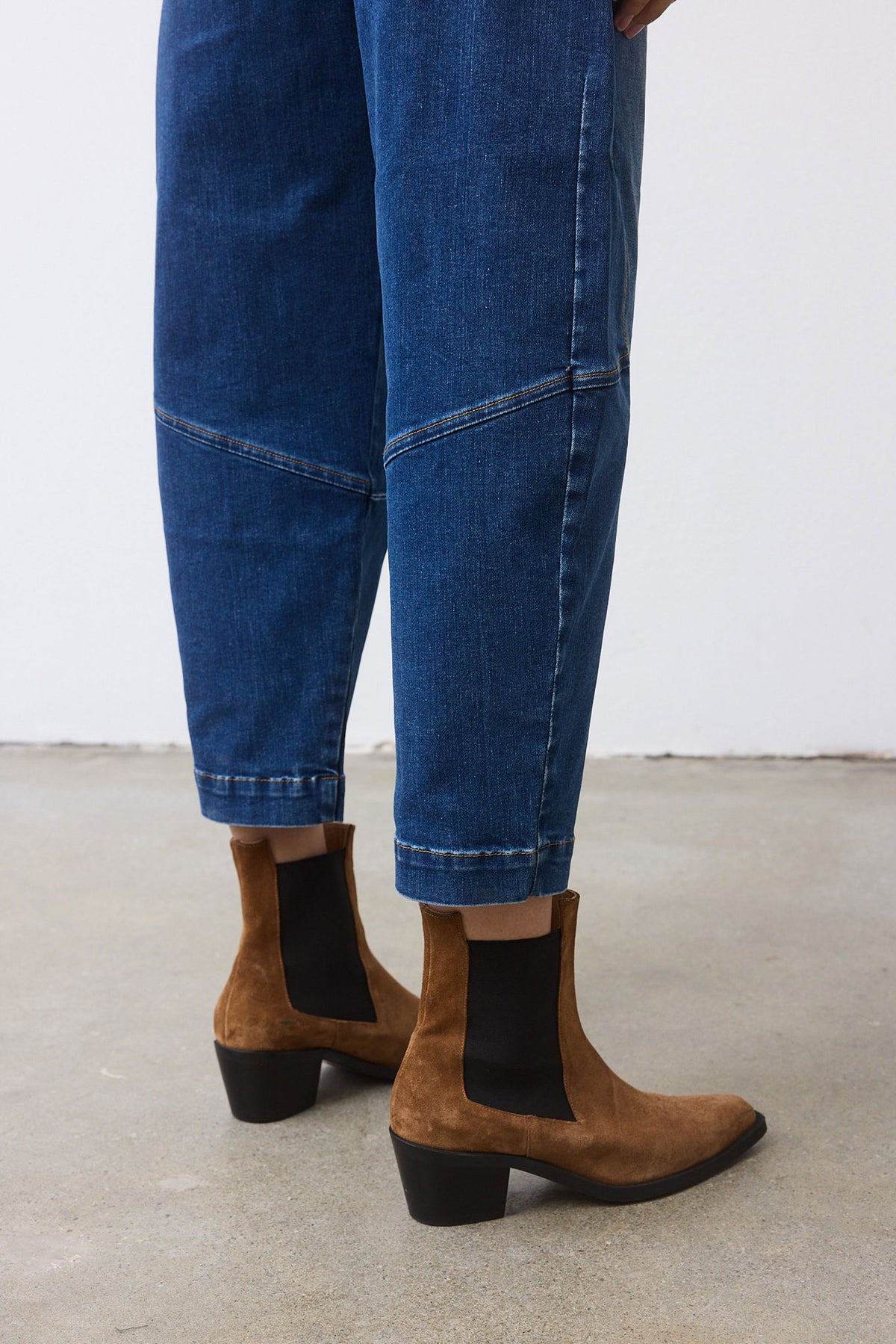 Medium-wash denim wide-leg pants with side seam stitching and cuffed hem