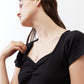 Black square-neck top with ruched neckline, close-up