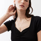 Black square-neck top with ruched front detail, close-up of neckline