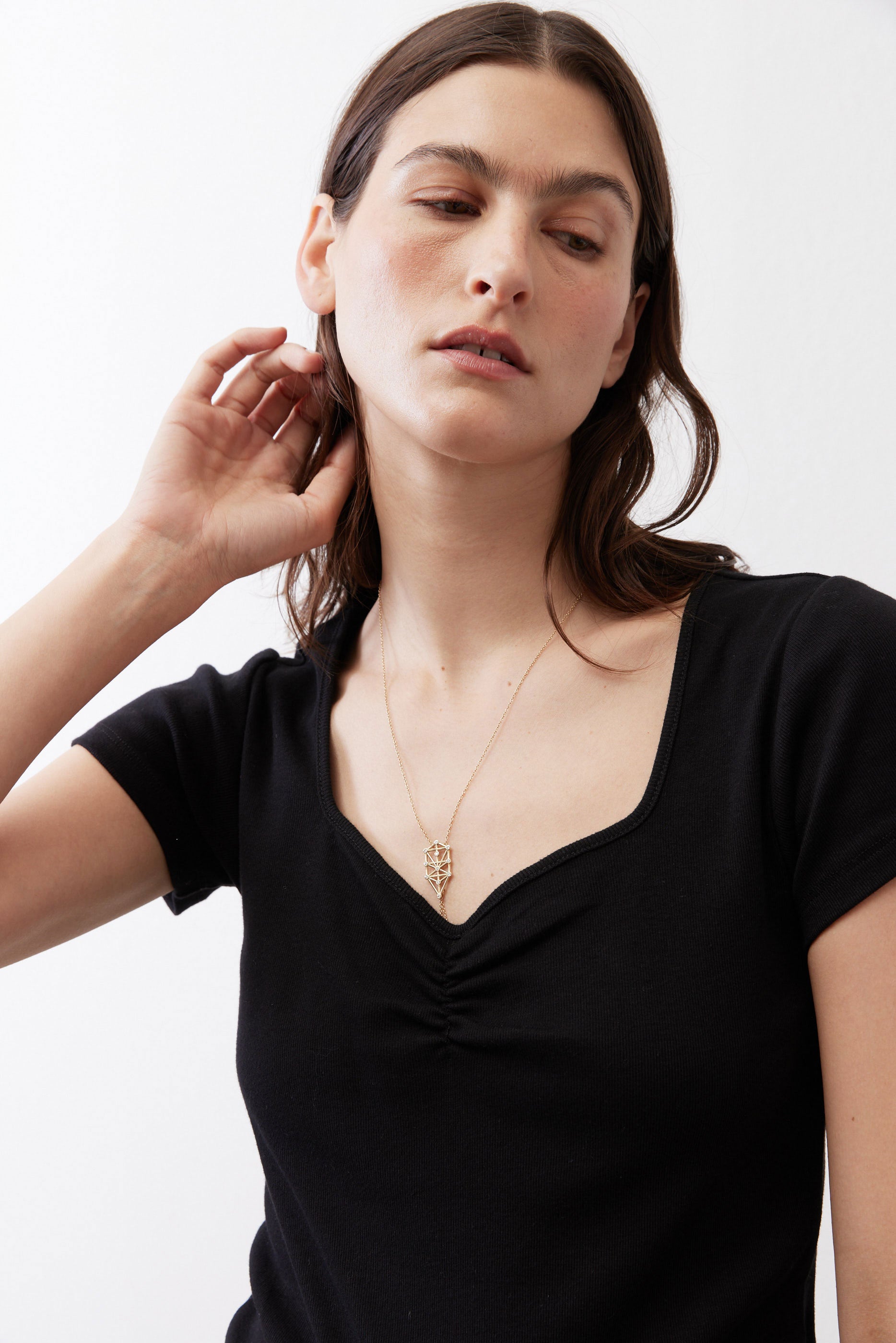 Black square-neck top with ruched front detail, close-up of neckline