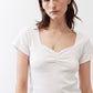 Ivory square-neck dipped top with short sleeves and V-shaped gathered bust detail