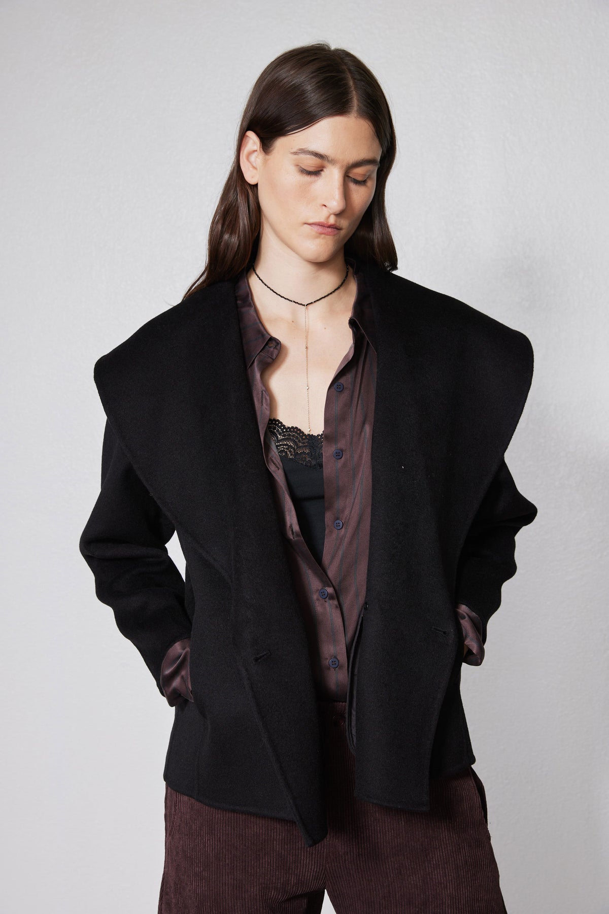 Black cropped wool coat with notch lapels, double-breasted front and button closure