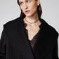 Black cropped wool coat close-up with wide collar, lapels, and two button details