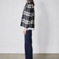 Cropped plaid wool coat side view in black and white checks with button front