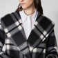 Close-up of plaid double-faced wool coat lapels and two dark buttons