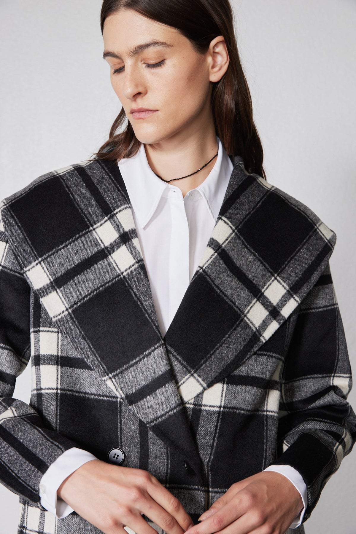 Close-up of plaid double-faced wool coat lapels and two dark buttons