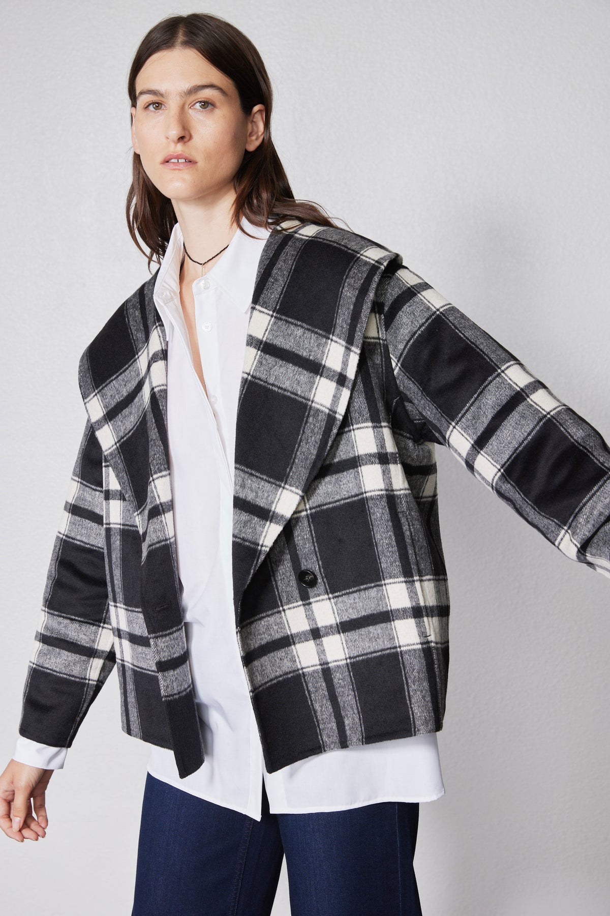Close-up of plaid wool coat with long sleeves and open front, black/white checks