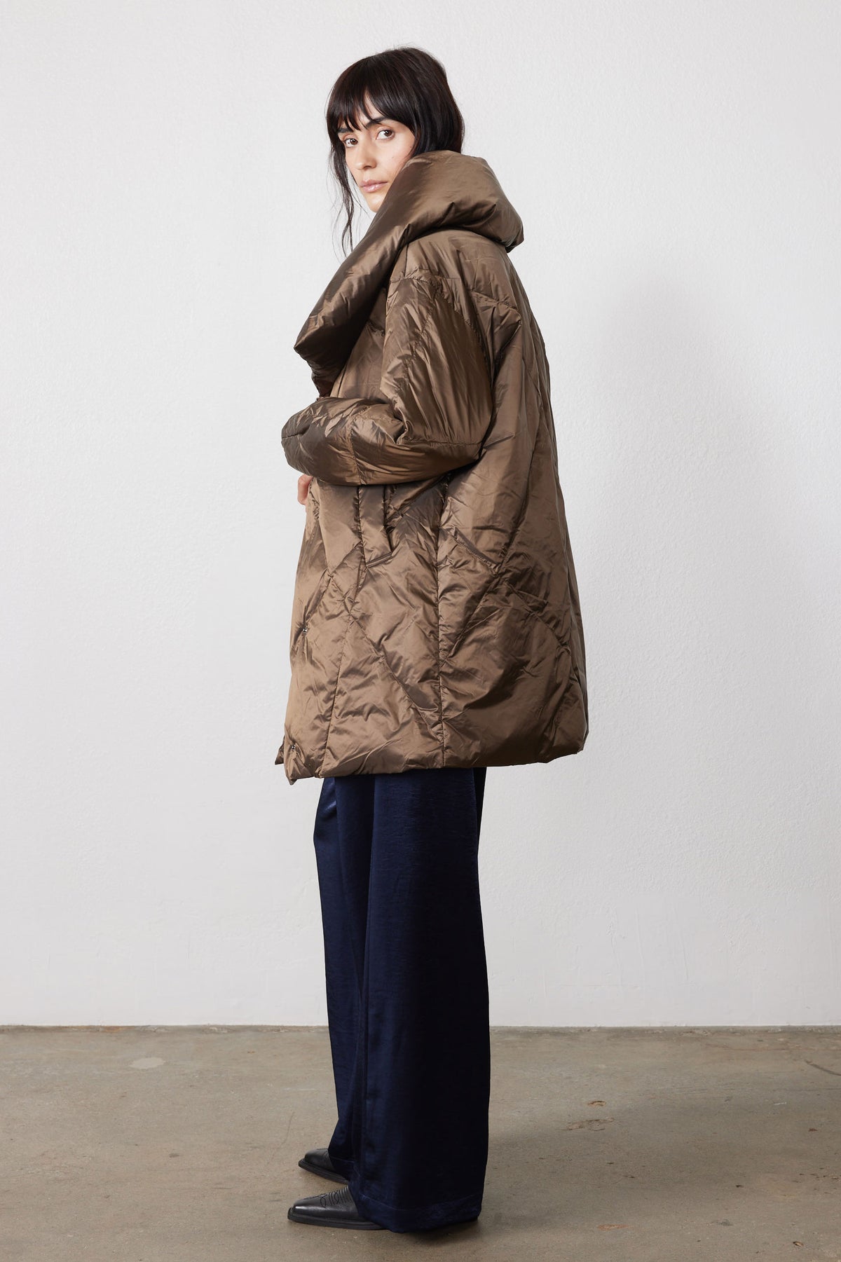 Side view of walnut puffer jacket with oversized collar and long hem