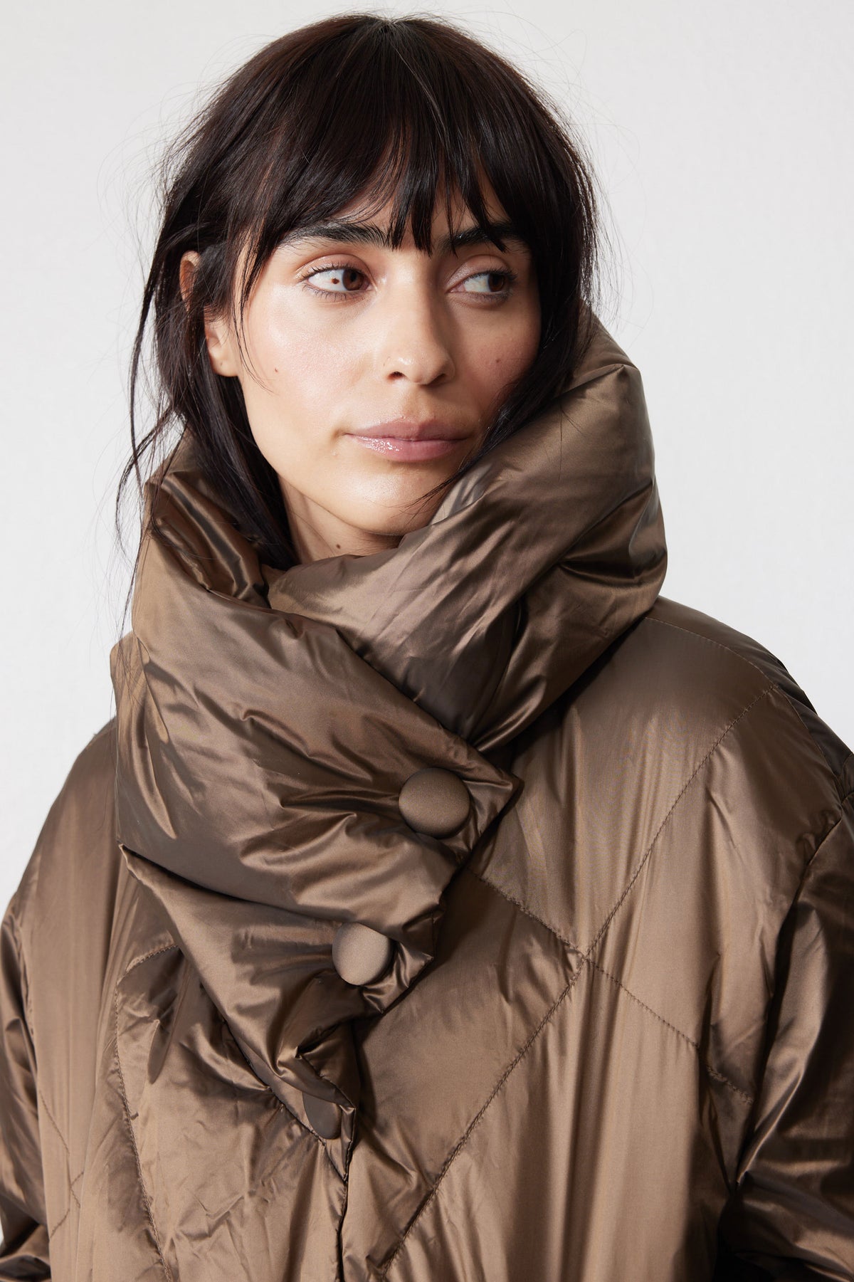 Close-up of oversized collar and snap fasteners on walnut puffer jacket