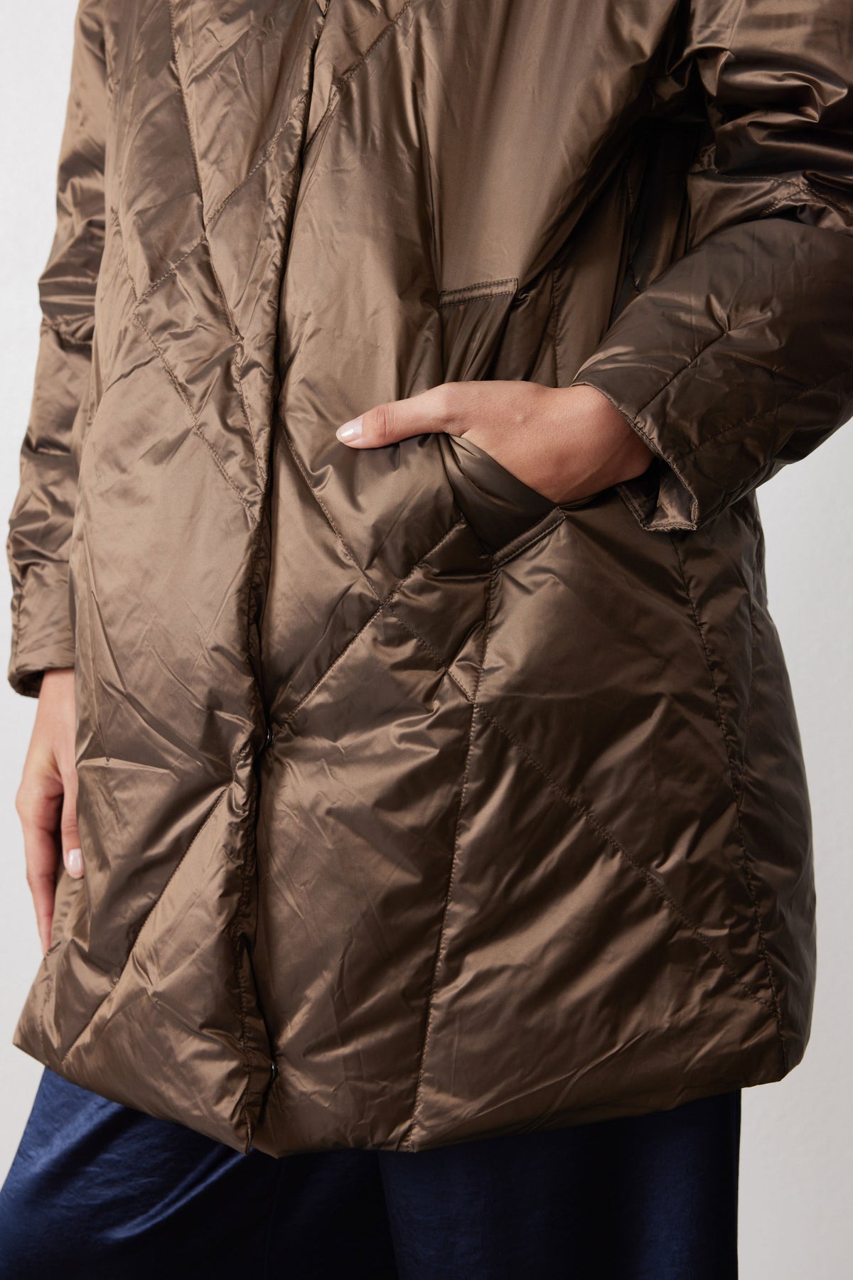 Close-up of pocket opening and stitched panels on walnut puffer jacket