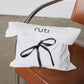 Folded sweater lounge set with black ribbon bow and stitched neckline, off-white fabric