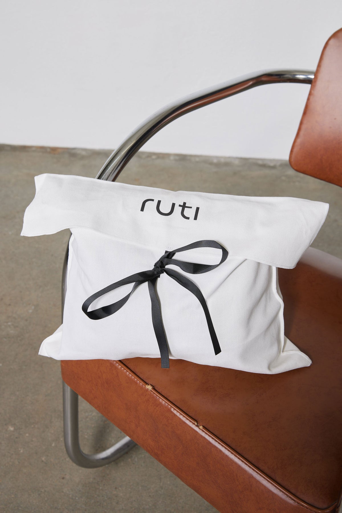 Folded sweater lounge set with black ribbon bow and stitched neckline, off-white fabric