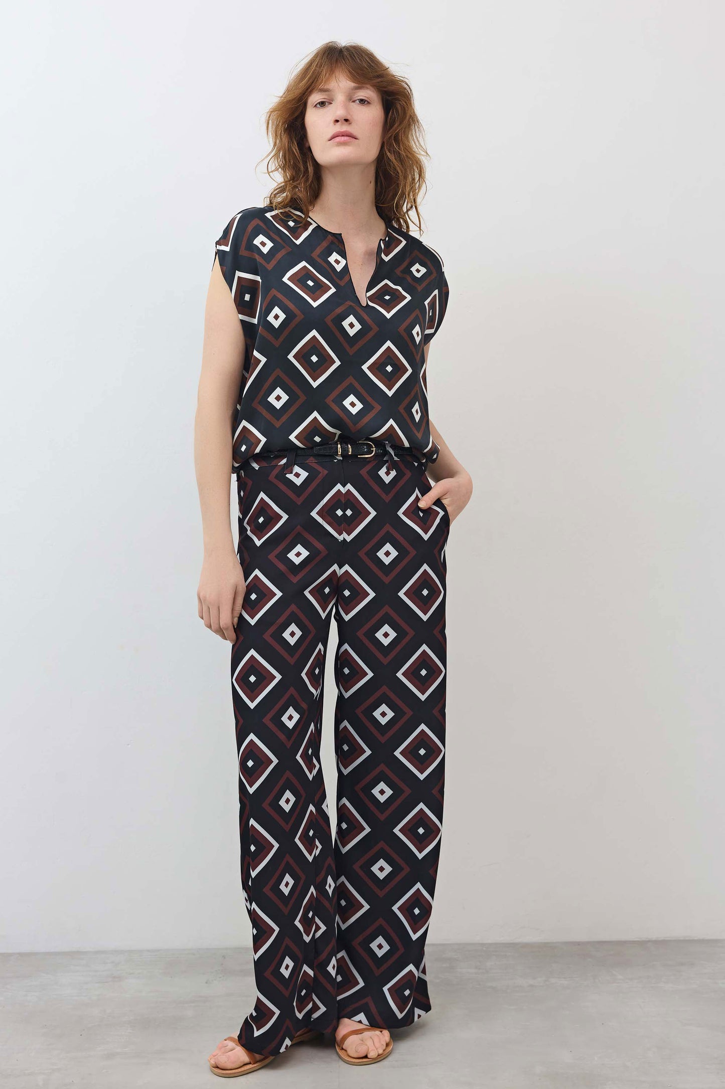 Wide-leg trousers with repeating diamond geometric print on dark base