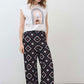 White sleeveless graphic tee with centered rainbow arch print and curved hem