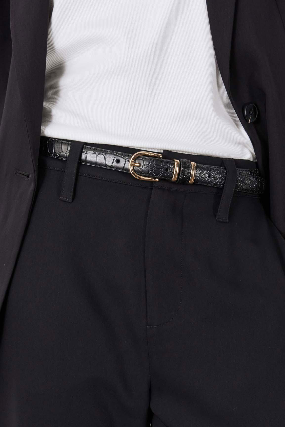 Black croc-embossed belt with gold buckle between blazer and trousers
