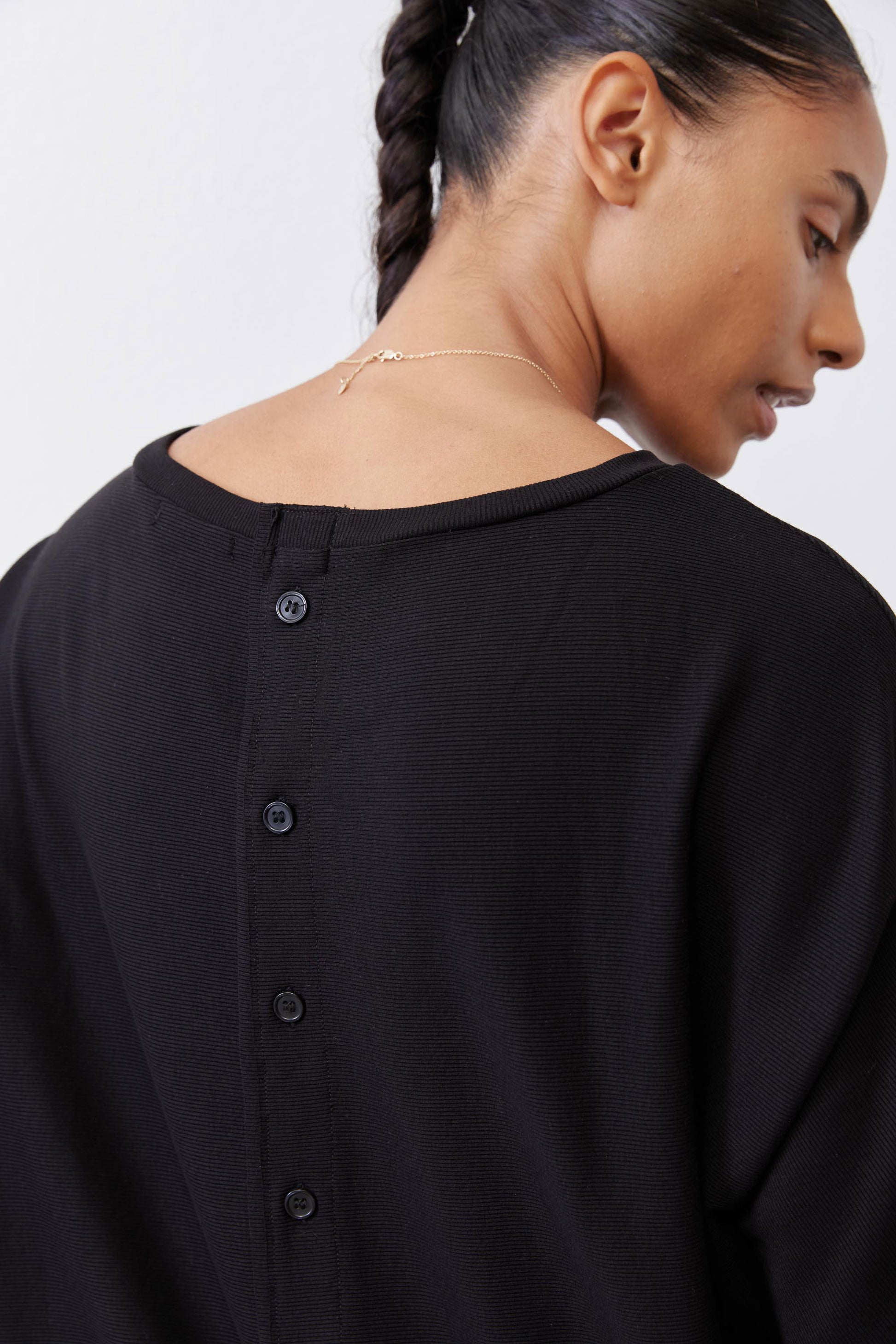 Black short-sleeve top back with four-button placket detail