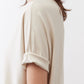 Cloud cream short-sleeve top back view, draped shoulder and sleeve cuff