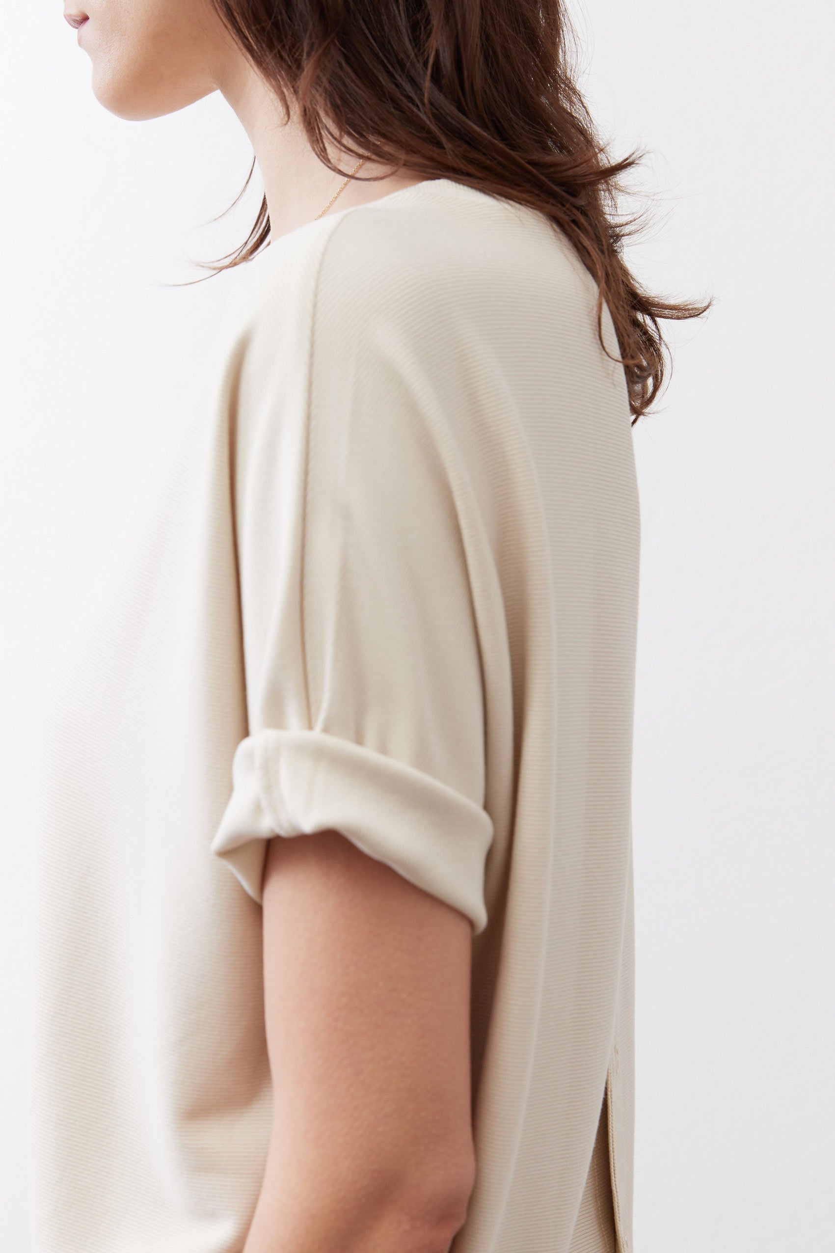 Cloud cream short-sleeve top back view, draped shoulder and sleeve cuff