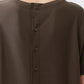 Olive short-sleeve top back close-up with button placket and ribbed texture